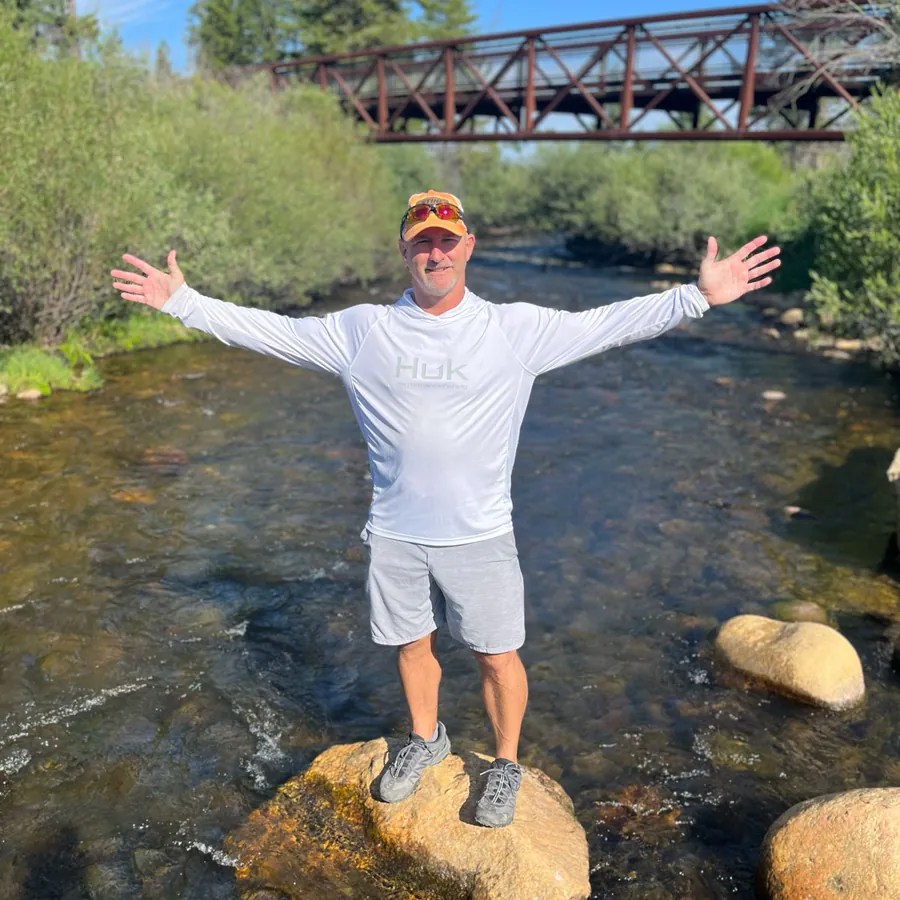 Chance enjoying time outdoors, standing on a rock in a river